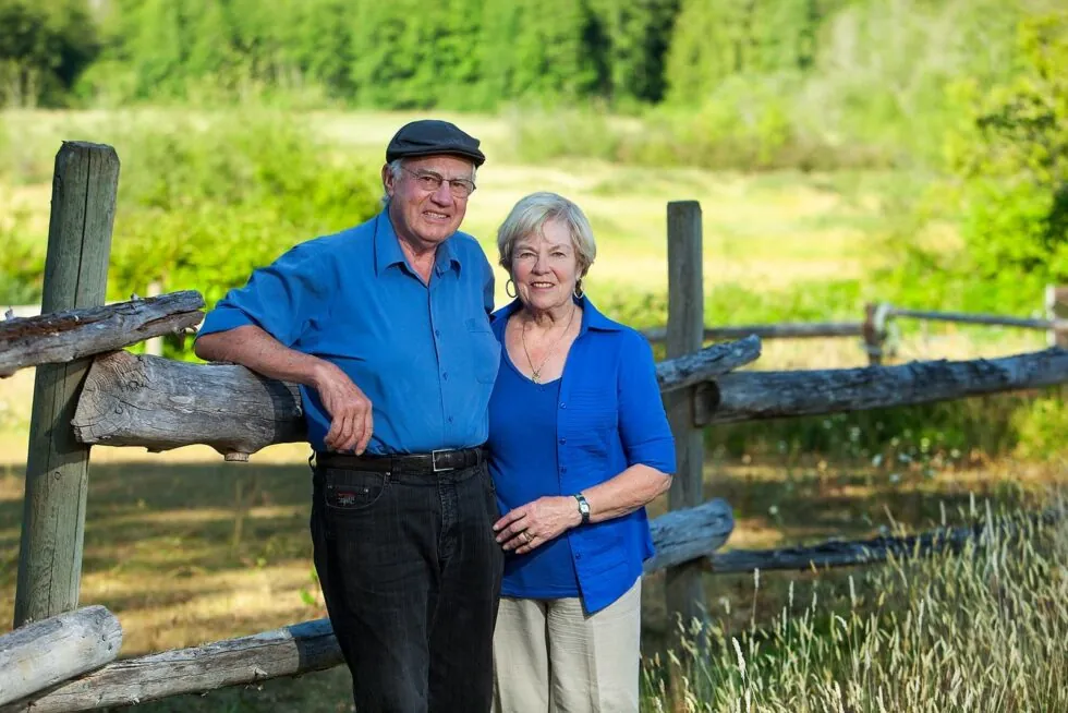 Hertels founding couple leaning on fence
